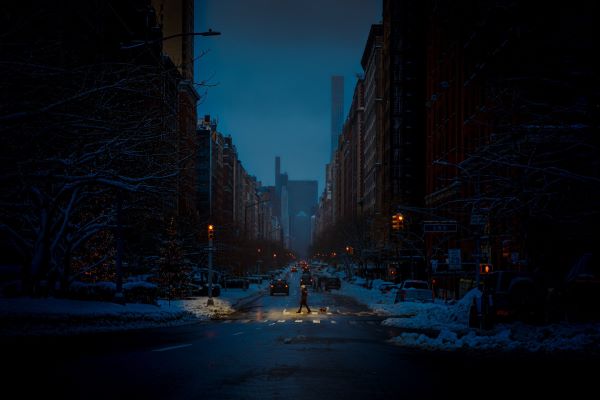 Pedestrian crossing a dark street.