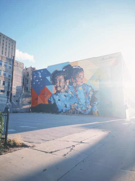 Image shows a mural of two children smiling over geometric background