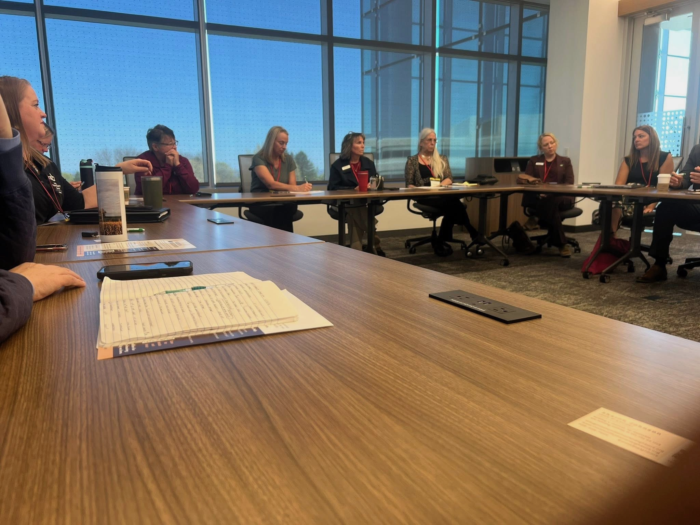 Conference Table with Attendees Discussing Key Housing Topics