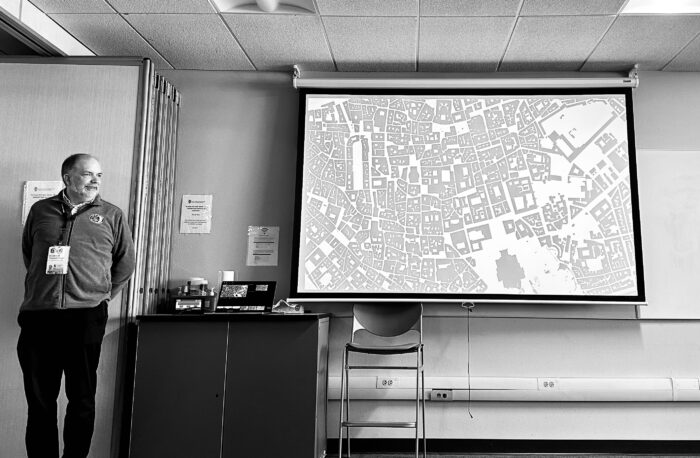 Guest Speaker, Black and White Image, Map displayed on large screen for group discussion