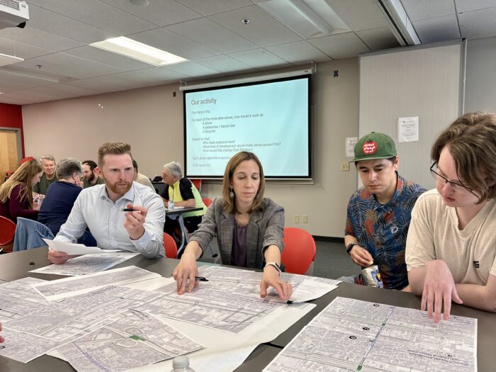 Madison Community Transportation Academy participants looking at maps on a table