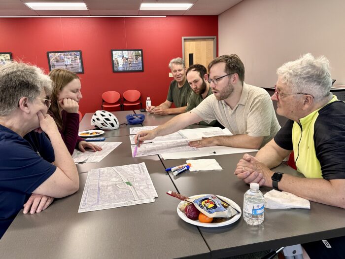 Group discussion at table while analyzing maps as part of the Madison Community Transportation Academy