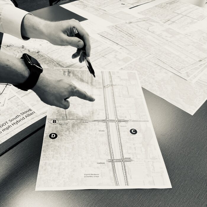 Black and White close-up photo of participant pointing at map on table during Madison Community Transportation Academy