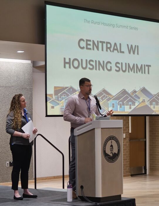 Speakers at the podium at the Central Wisconsin Housing Summit in Stevens Point