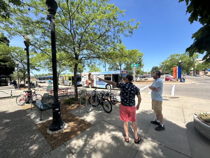 Pedestrians in Stevens Point wait by bike racks and bus stop